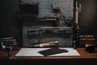 a table with a gun, rifle, and other items on it
