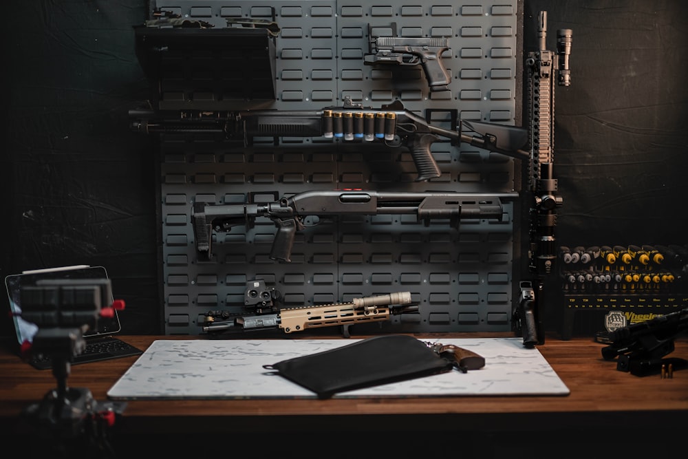 a table with a gun, rifle, and other items on it