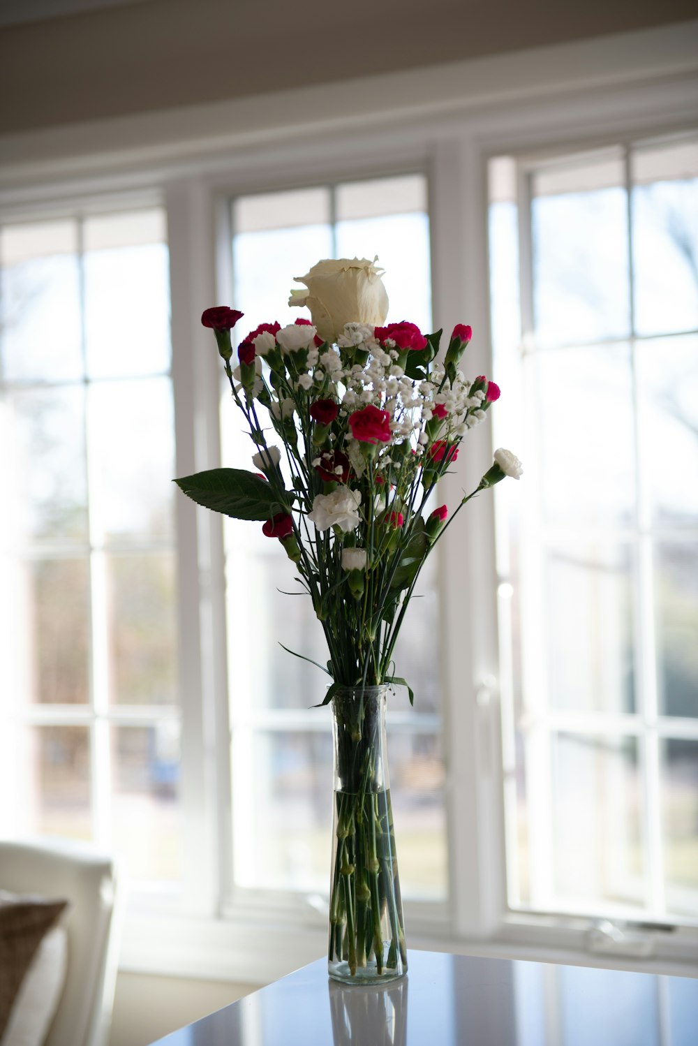 A vase of flowers on a table in front of a window photo – Free Flower Image  on Unsplash