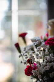 Close-up of a luxurious floral arrangement with soft pastel roses and greenery in natural light.