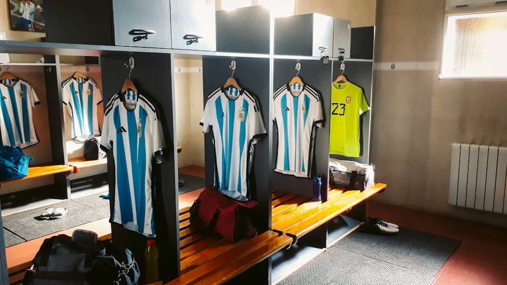 a locker room with a number of shirts hanging on the wall