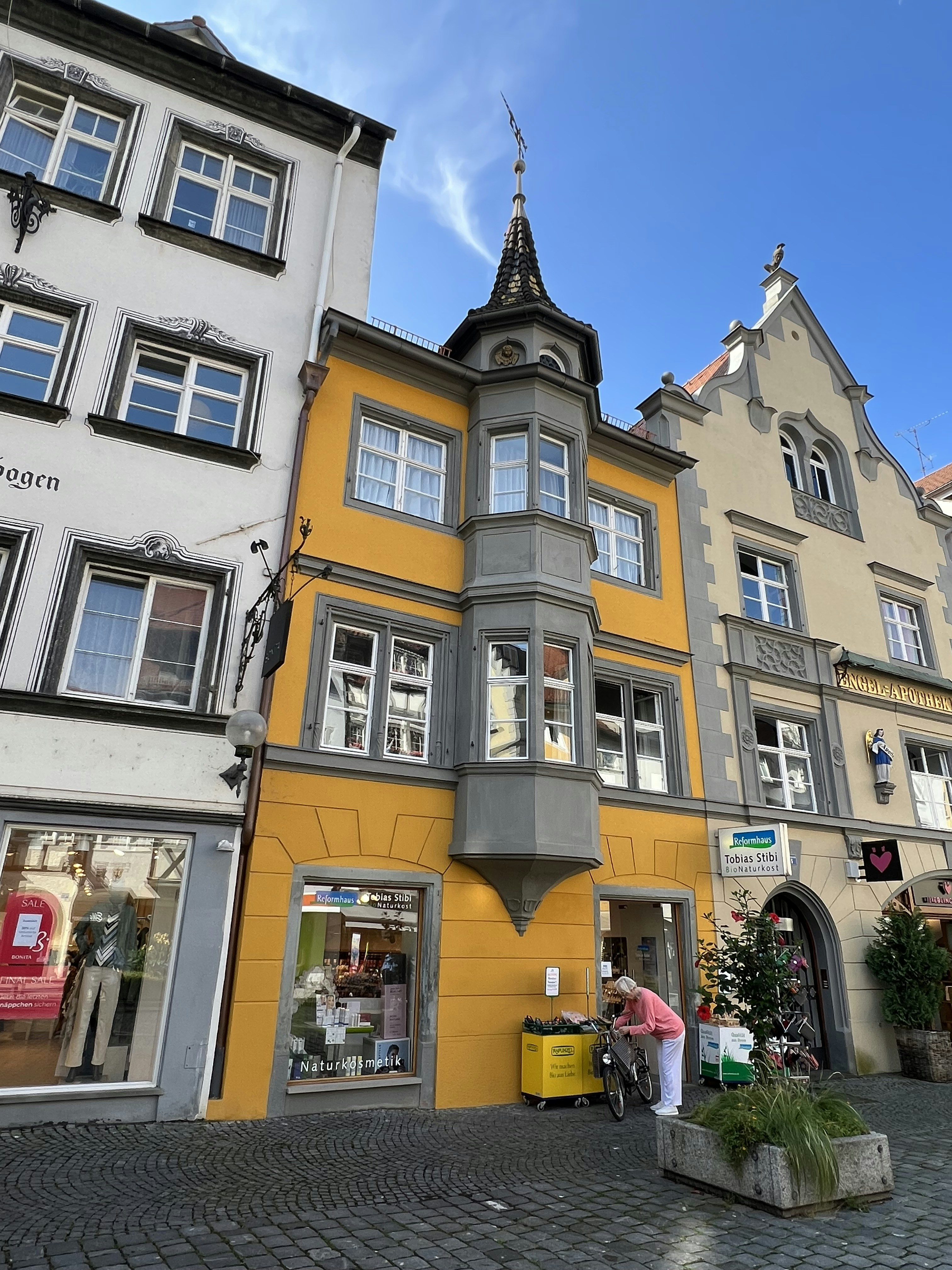 a yellow and grey building on a cobblestone street