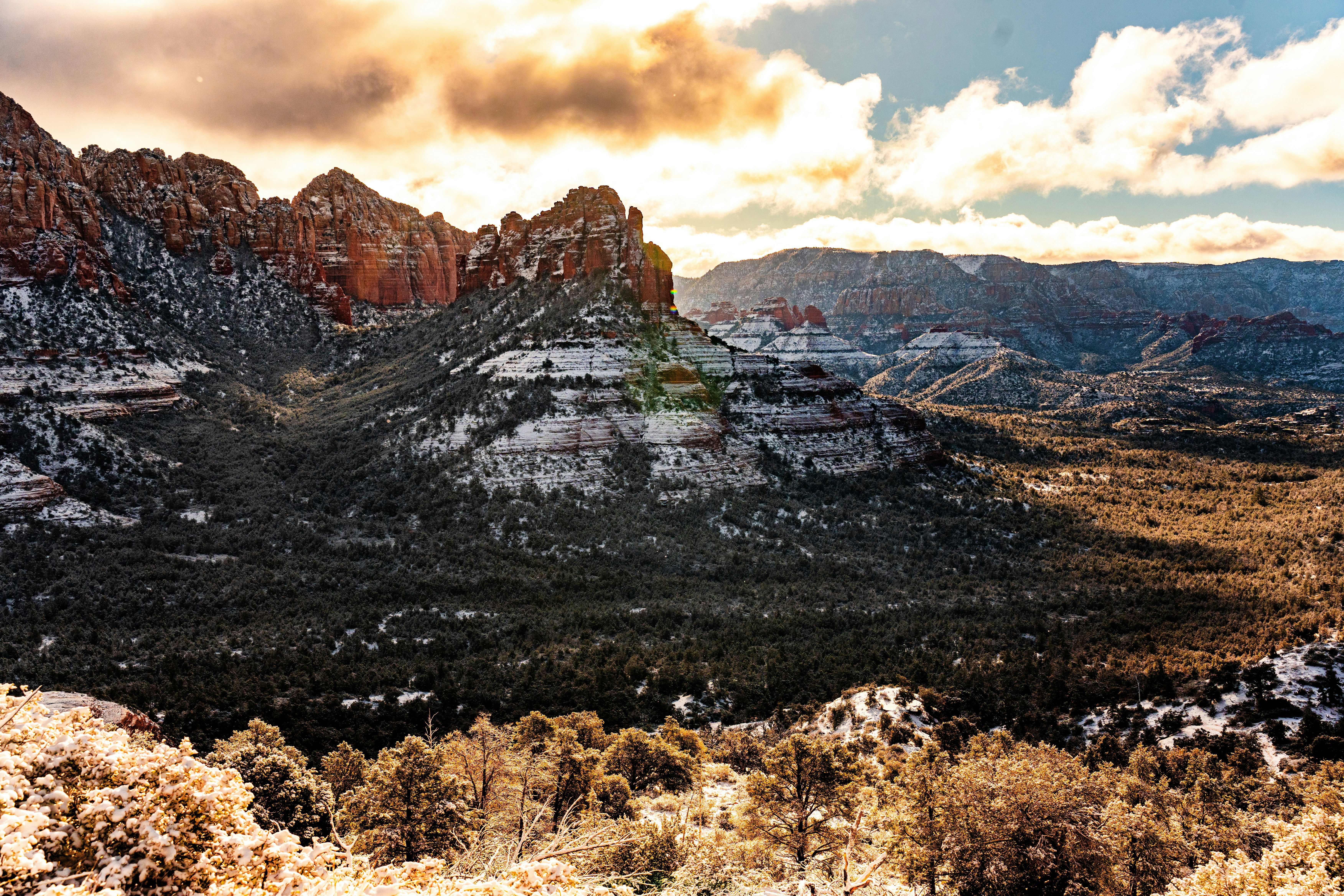 a scenic view of a mountain range with snow on the ground