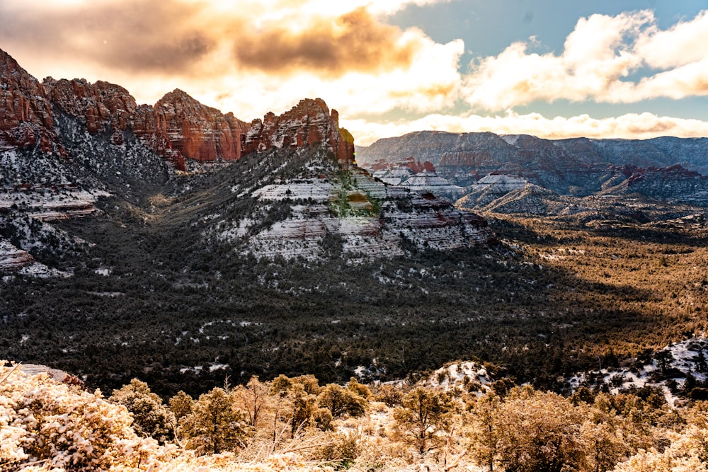 Una vista panorámica de una cadena montañosa con nieve en el suelo