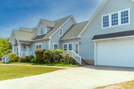 a white house with a large driveway in front of it