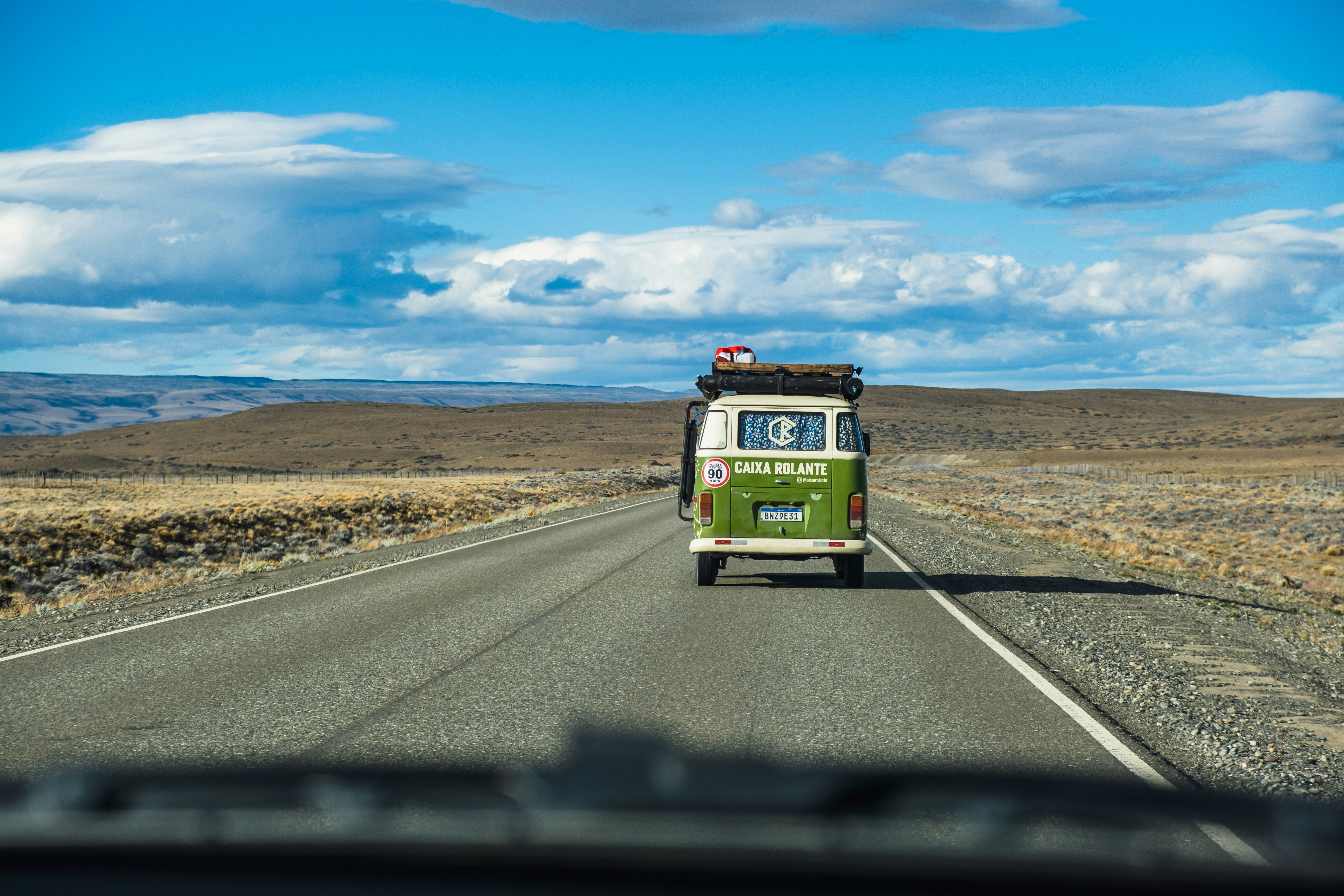 a green and white bus driving down a road, 
