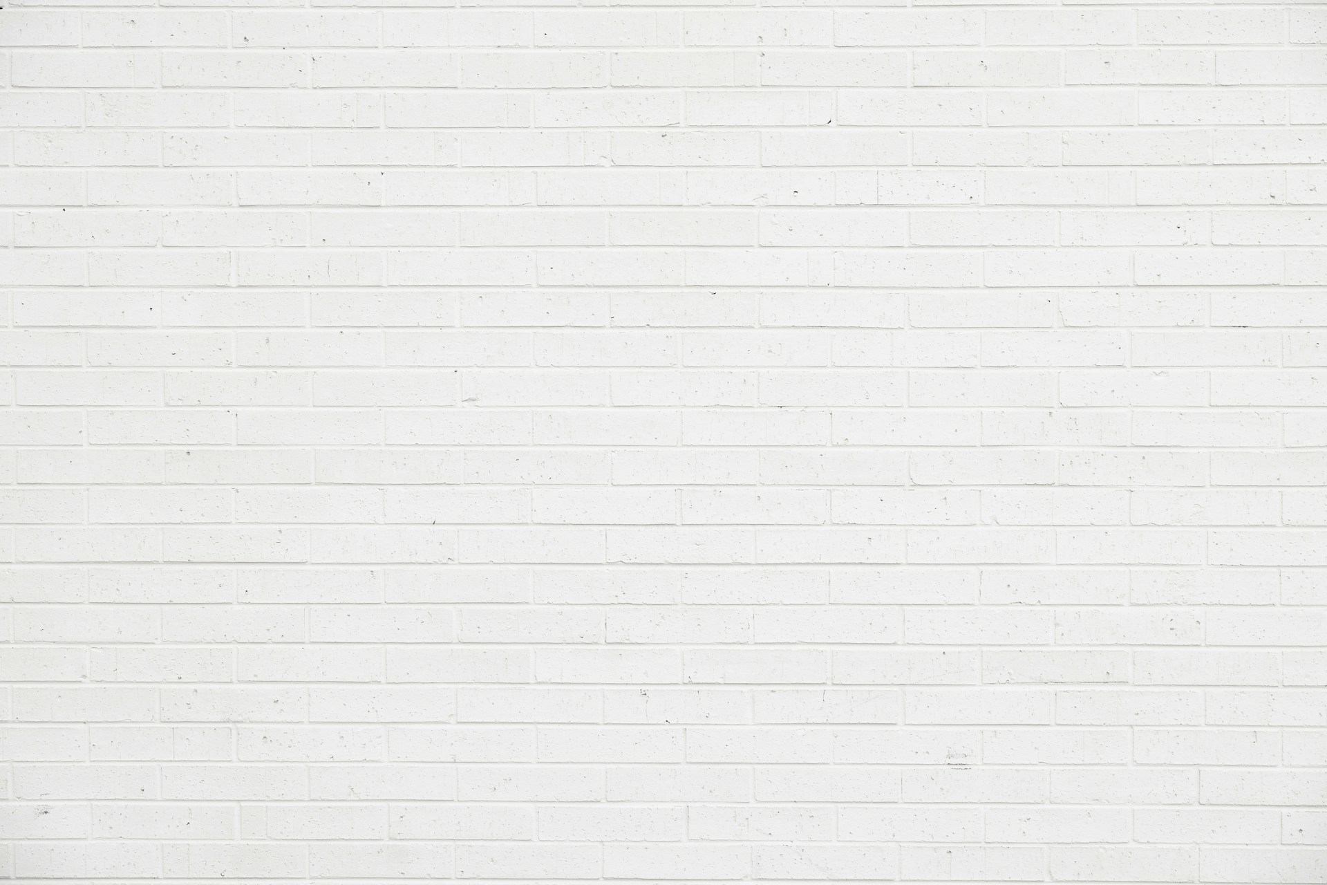 a woman standing in front of a white brick wall