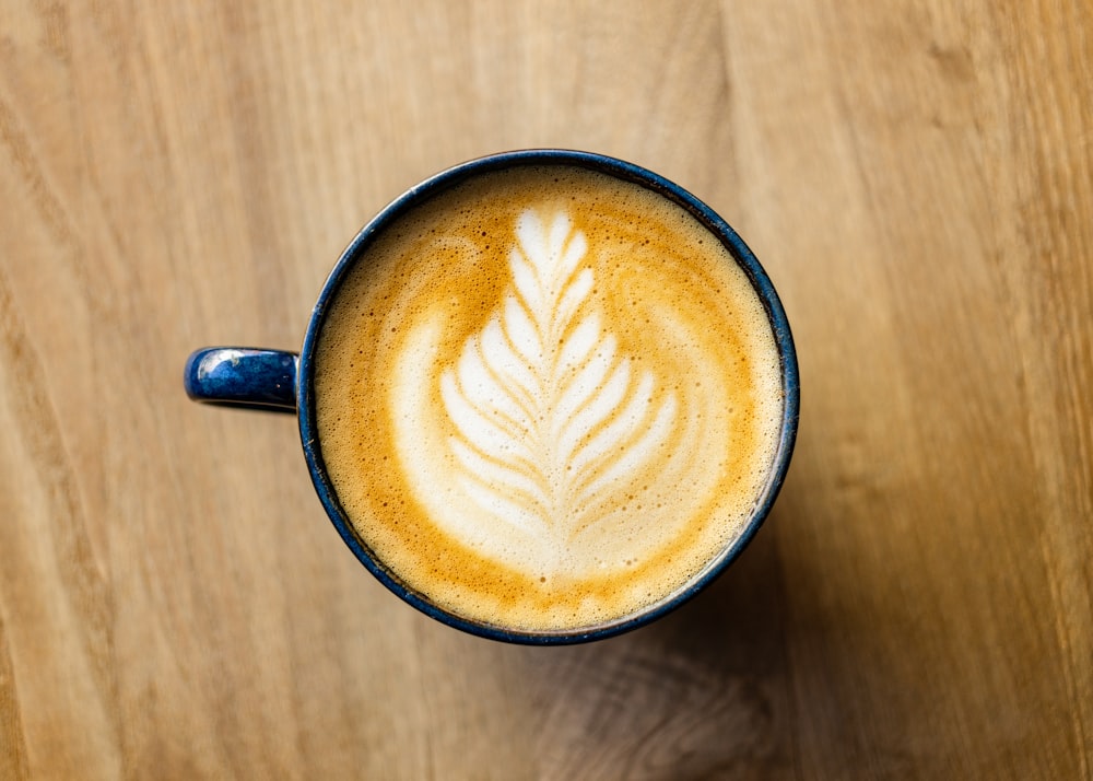 a cup of coffee with a leaf drawn on it