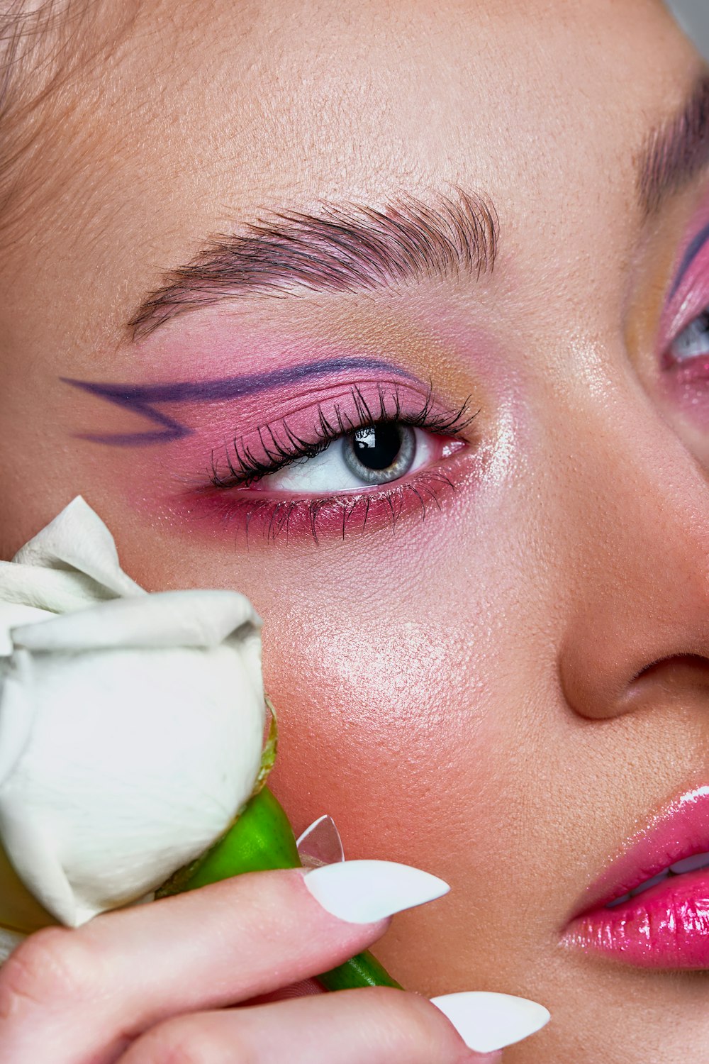 a close up of a woman with a flower in her hand