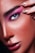 A close-up of a person's face featuring detailed eye makeup with bright pink eyeshadow. The eye is blue, and the eyebrows are dark and well-defined. The skin has visible freckles and a glossy finish. A hand with fingernails decorated with black designs is gently touching the eye area.
