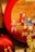 A decorative item with an intricate design depicting children dressed in traditional clothing, vividly painted, and set against a red circular background. Chinese calligraphy is prominently displayed on a vertical red strip. The surrounding elements include additional festive decorations and a golden sculpture.