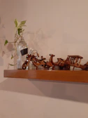 Finished architectural miniature models displayed on a wooden shelf, highlighting craftsmanship.