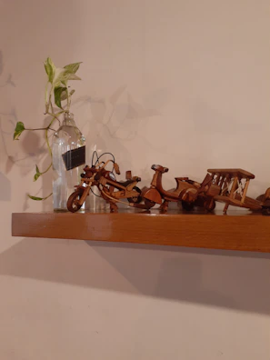 Finished architectural miniature models displayed on a wooden shelf, highlighting craftsmanship.