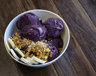 a bowl of ice cream with bananas and granola