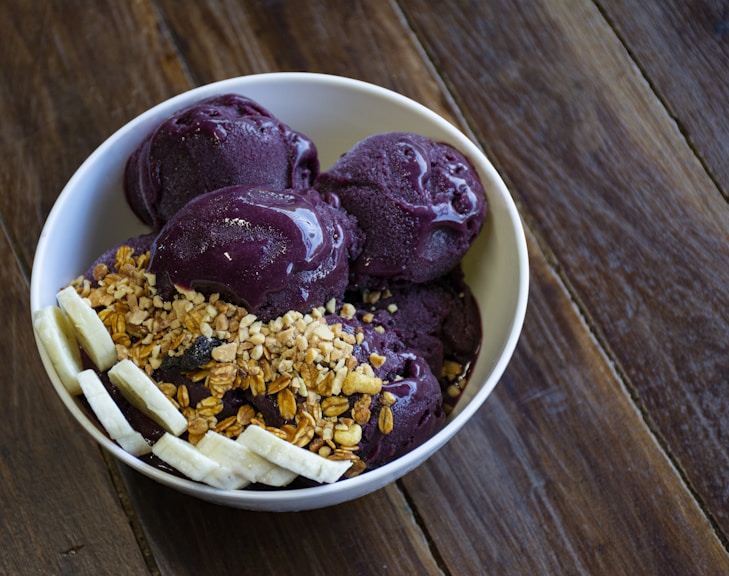 a bowl of ice cream with bananas and granola