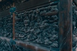 Intricate carvings of the Pangool spirits on weathered wooden statues.