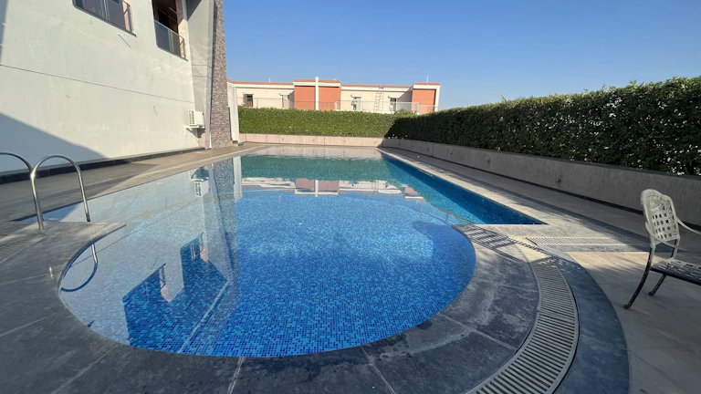 Modern pool heat pump installed beside a clear blue swimming pool