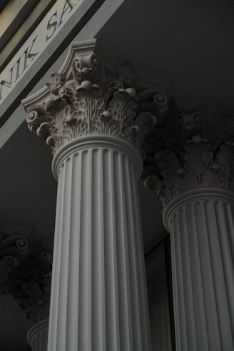 a close up of some white pillars with a building in the background