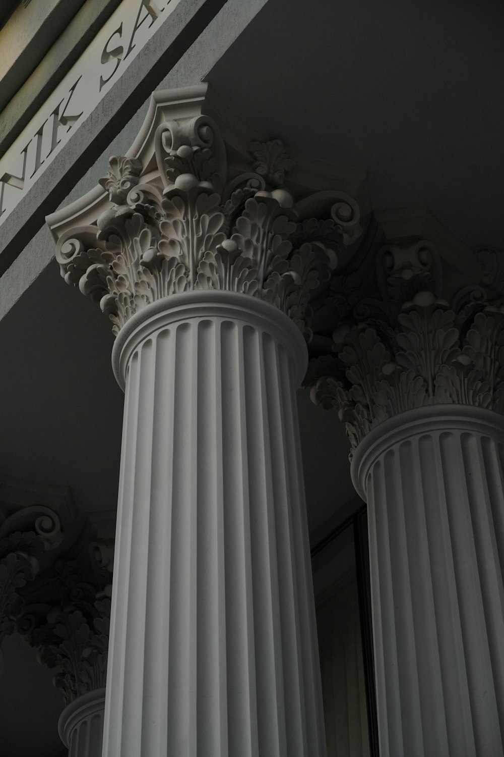 a close up of some white pillars with a building in the background