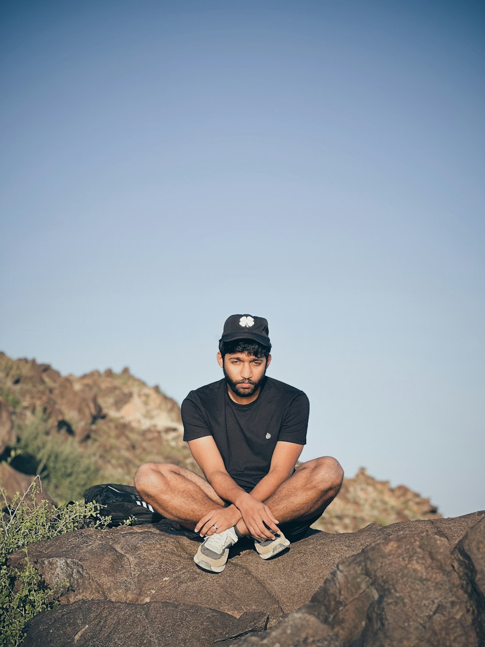 a man sitting on top of a large rock