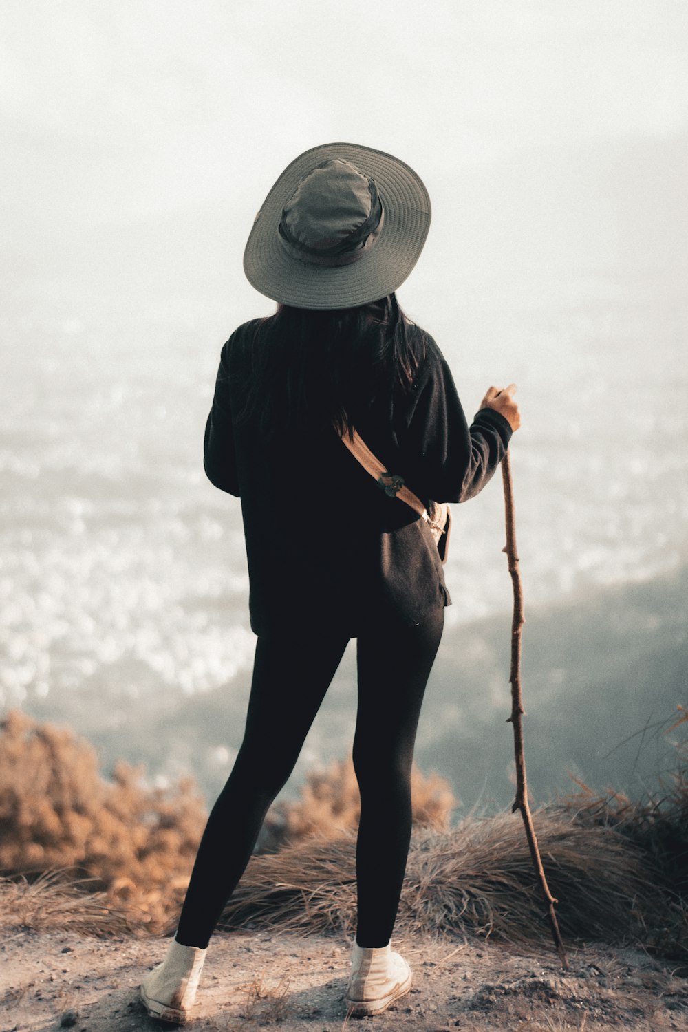 a person standing on a hill with a hat on