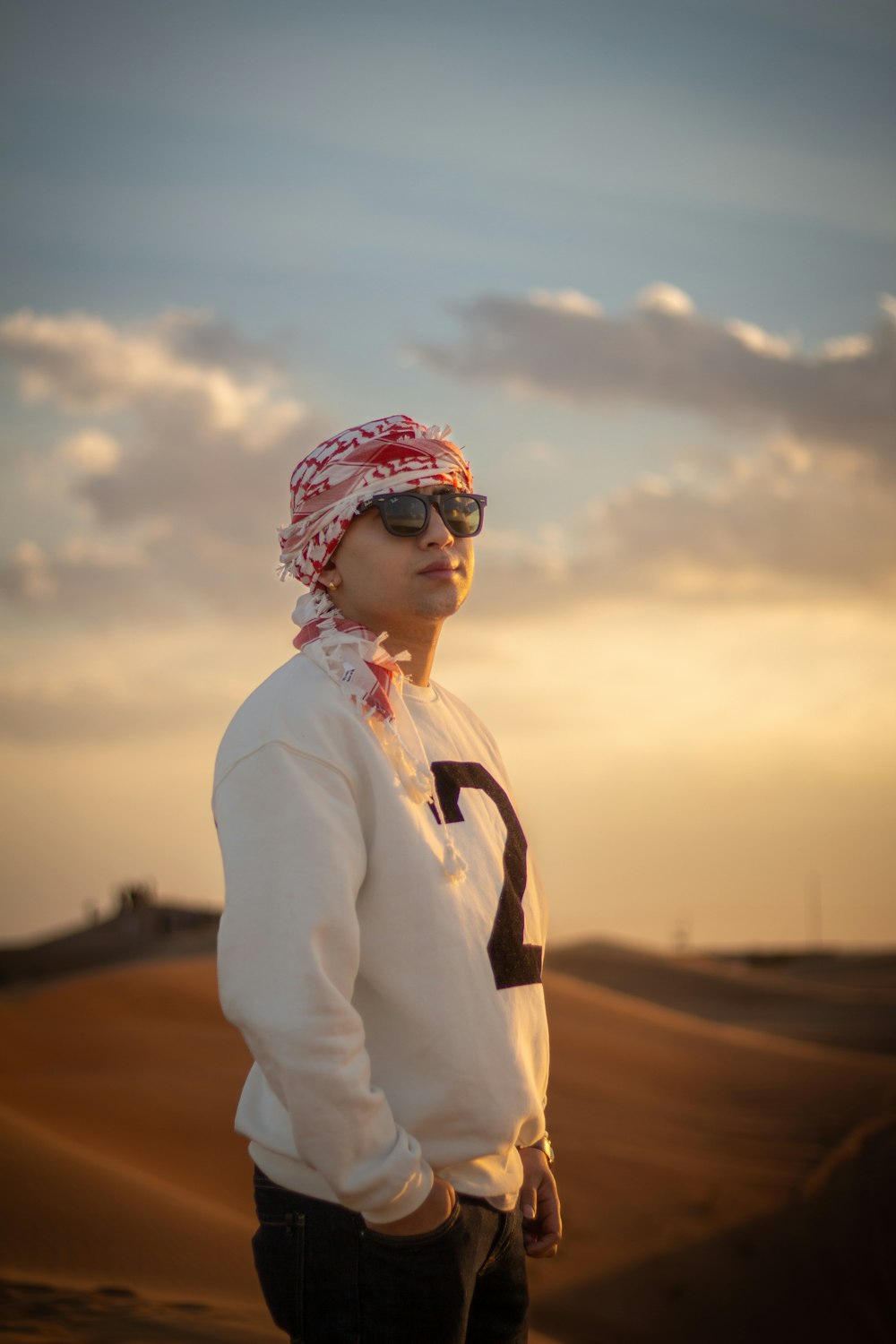 a man wearing a bandana standing in the desert