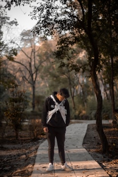 a man standing on a walkway in the woodsEmpowering young men through mental health retreats