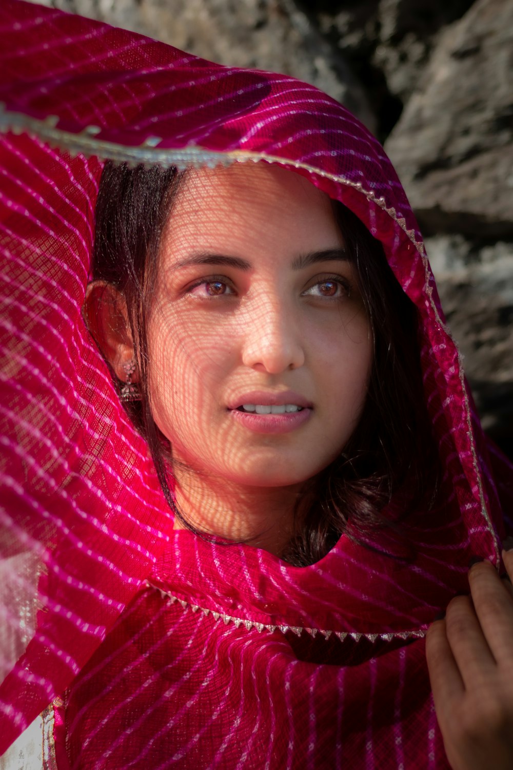 a woman in a red shawl is holding an umbrella