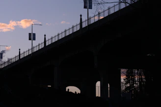 A scenic view of a quiet urban bridge at sunset, symbolizing journeys and hope.