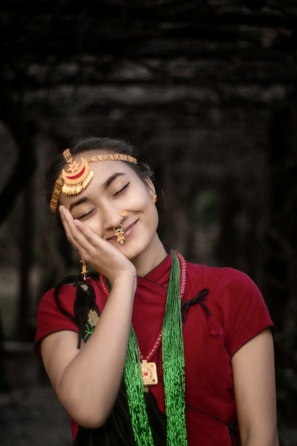 a woman in a red shirt is holding her hands to her face