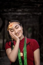a woman in a red shirt is holding her hands to her face