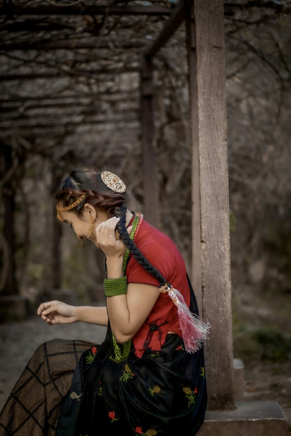 a woman sitting on a bench in a forest