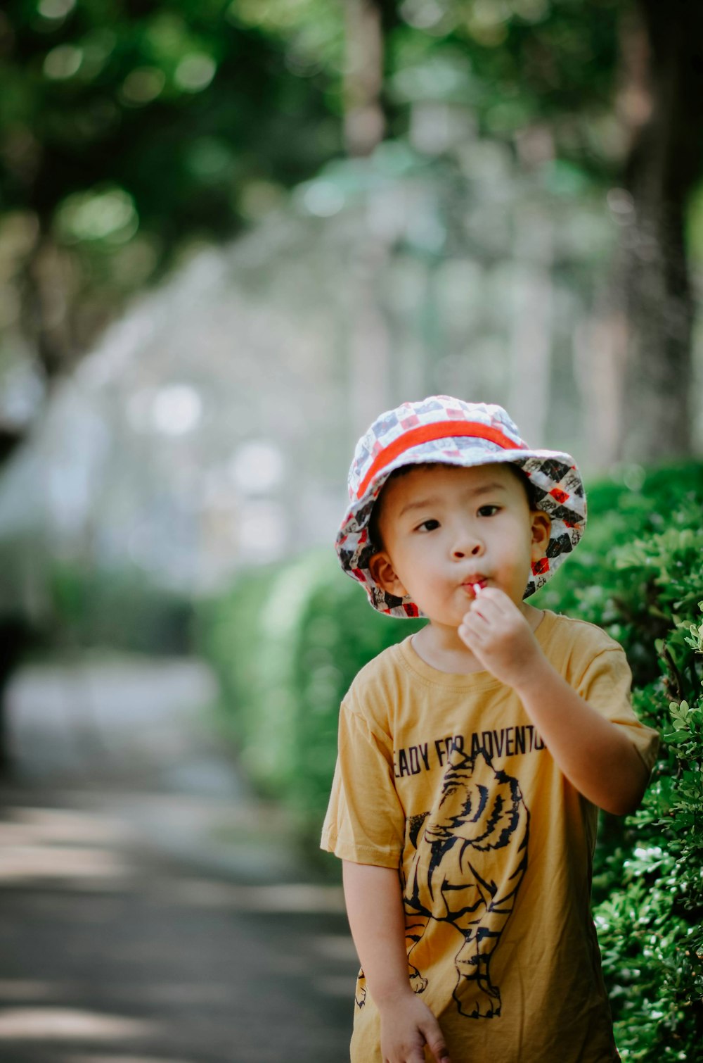 a young boy wearing a hat and eating something
