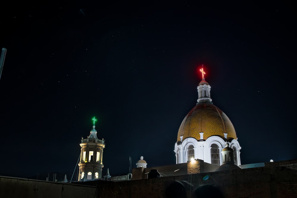 a building with a dome and a clock tower at night