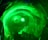 A group of silhouetted people are standing before a large, swirling green vortex or portal that is illuminated with bright light. The green lighting creates a mystical and otherworldly atmosphere.
