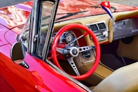 A red car with a steering wheel and dashboard