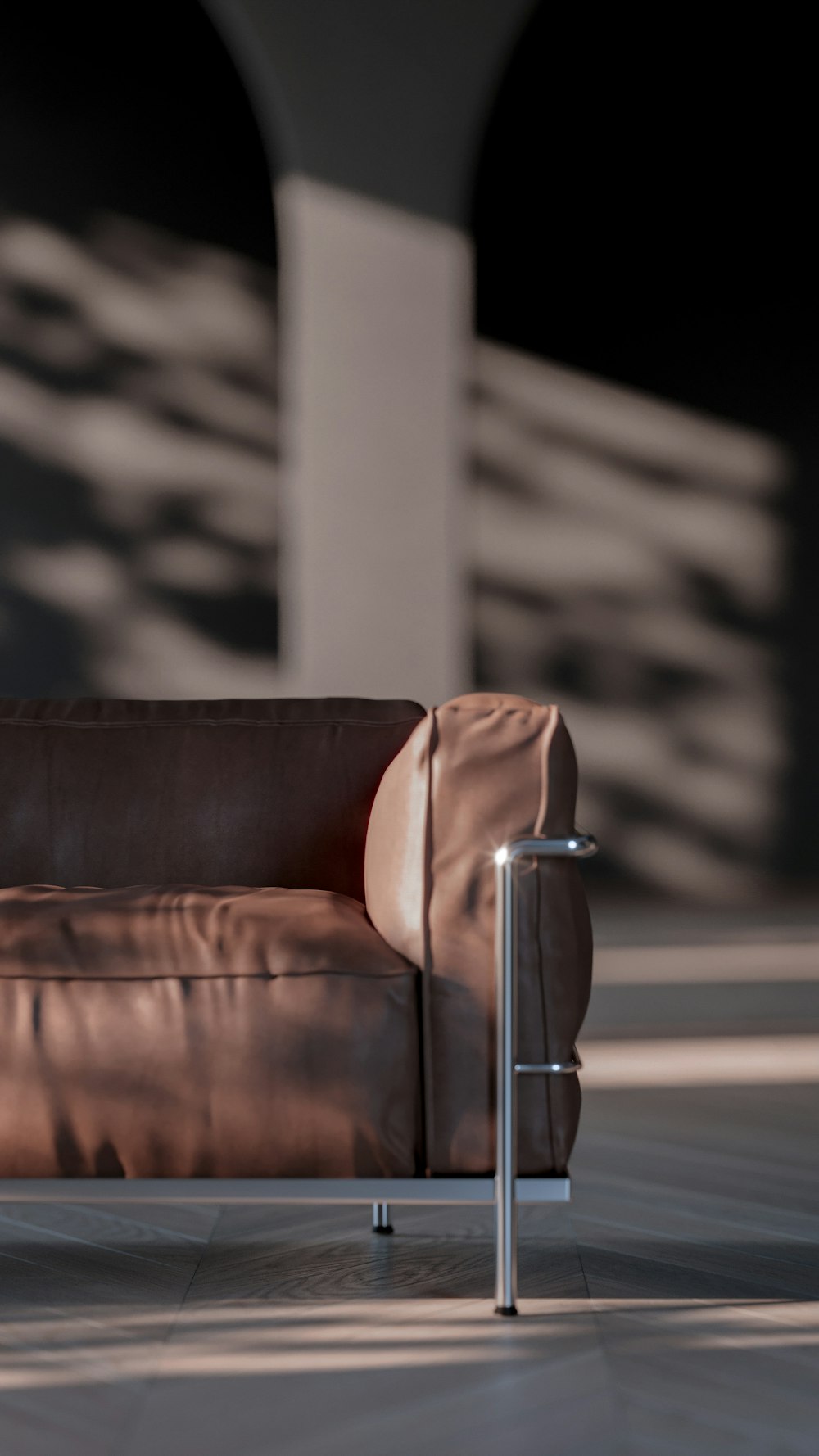 a brown couch sitting on top of a tiled floor