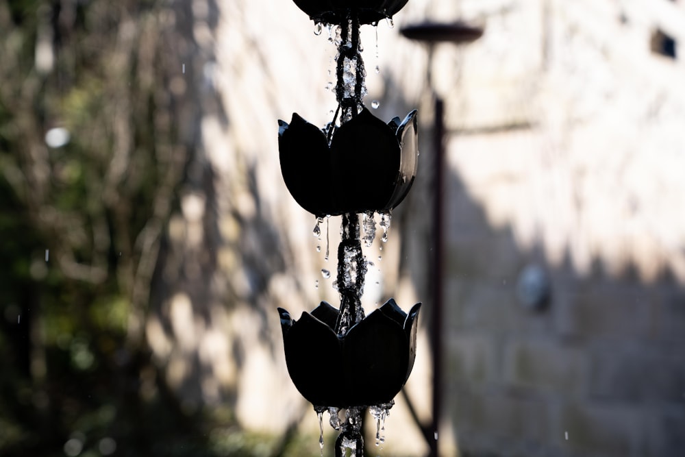 three black umbrellas hanging from a pole in the rain