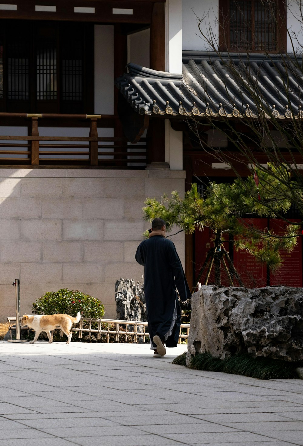 a man walking a dog in a courtyard