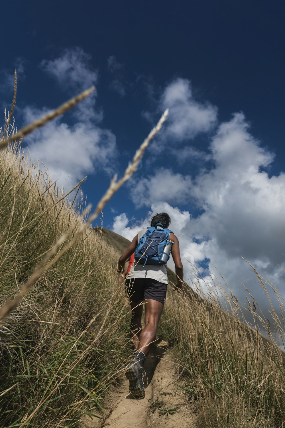 a person walking up a hill with a backpack