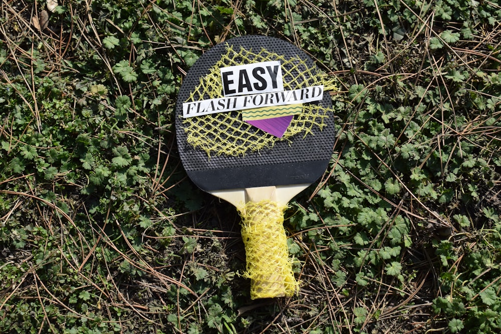a racket laying in the grass with the words easy forward on it
