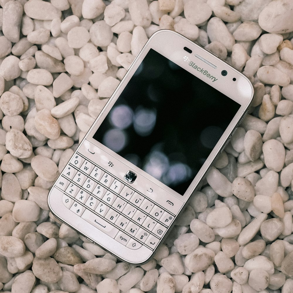 a cell phone laying on a bed of rocks