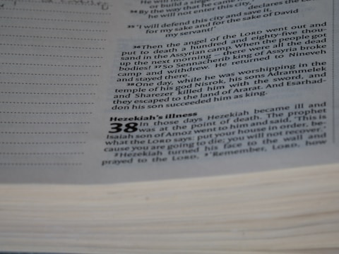 A close-up view of a page from a book with text printed on it. The text appears to be a passage from a biblical or religious text, discussing events involving Hezekiah and a prophet named Isaiah. The page has a section header that reads 'Hezekiah’s Illness' and includes numbered verses and additional lines for notation.