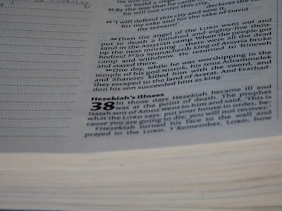 A close-up view of a page from a book with text printed on it. The text appears to be a passage from a biblical or religious text, discussing events involving Hezekiah and a prophet named Isaiah. The page has a section header that reads 'Hezekiah’s Illness' and includes numbered verses and additional lines for notation.