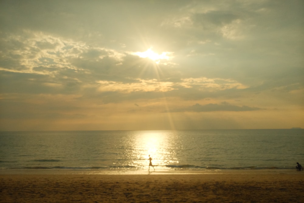 a person standing on a beach next to the ocean