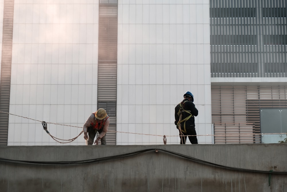 two people on a roof with a dog on a leash