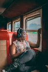 a woman sitting on a train looking out the window