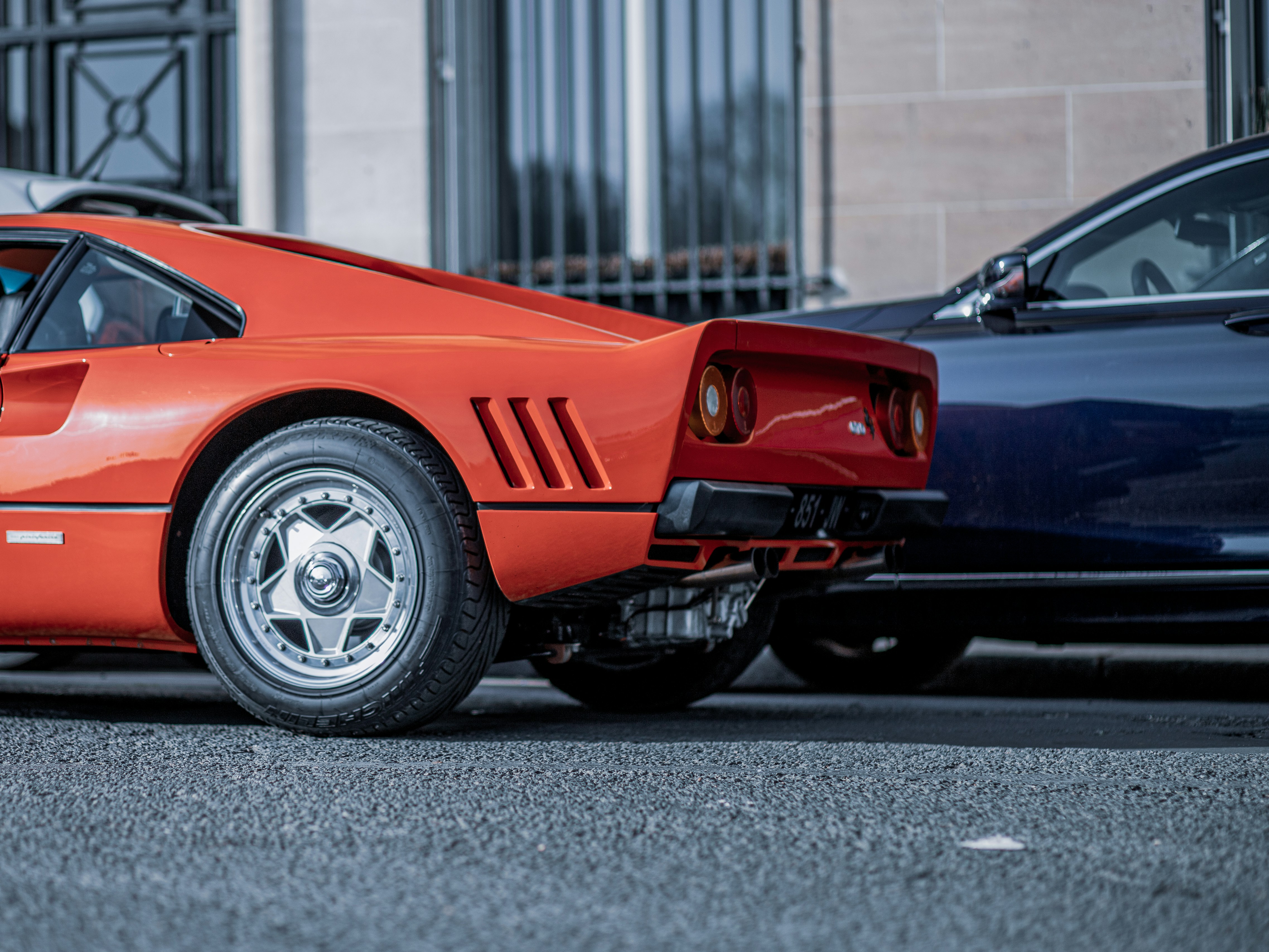 a red sports car parked next to a blue sports car