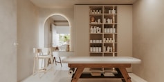 a room with a table, shelves, and chairs in it