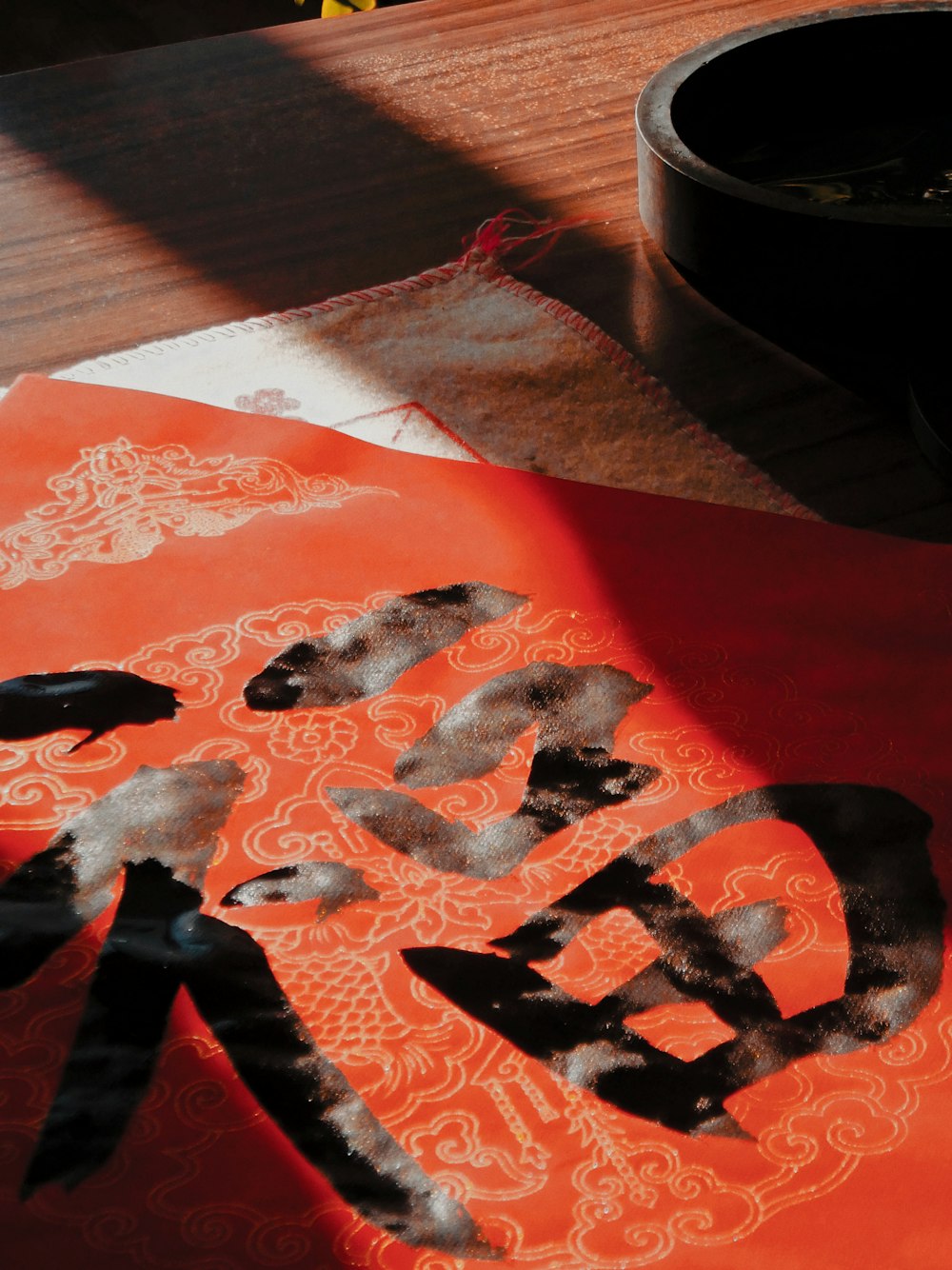 a painting on a table with a bowl of flowers in the background